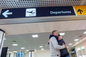 Abbraccio all'aeroporto sotto l'insegna delle partenze
